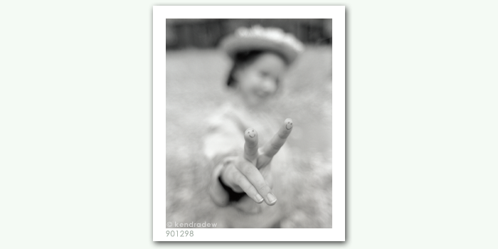 photograph of girl with smiley hand