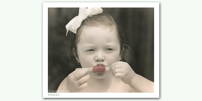 photograph of girl eating popsicle