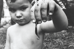 photograph of boy with worm